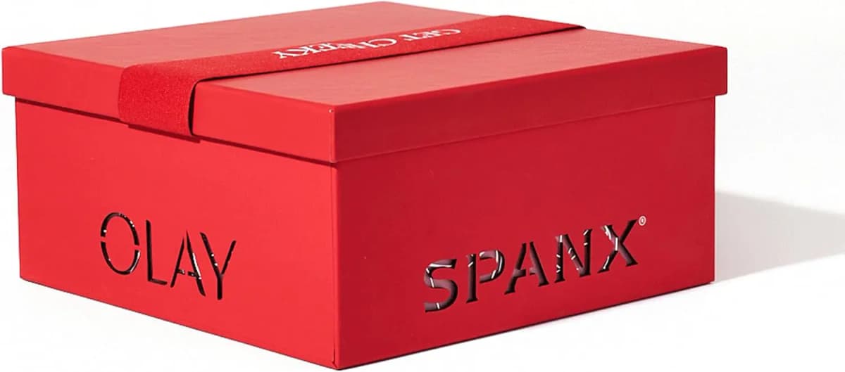 Red OLAY and SPANX bundle box with a red elastic Get Cheeky band across the lid on a white background