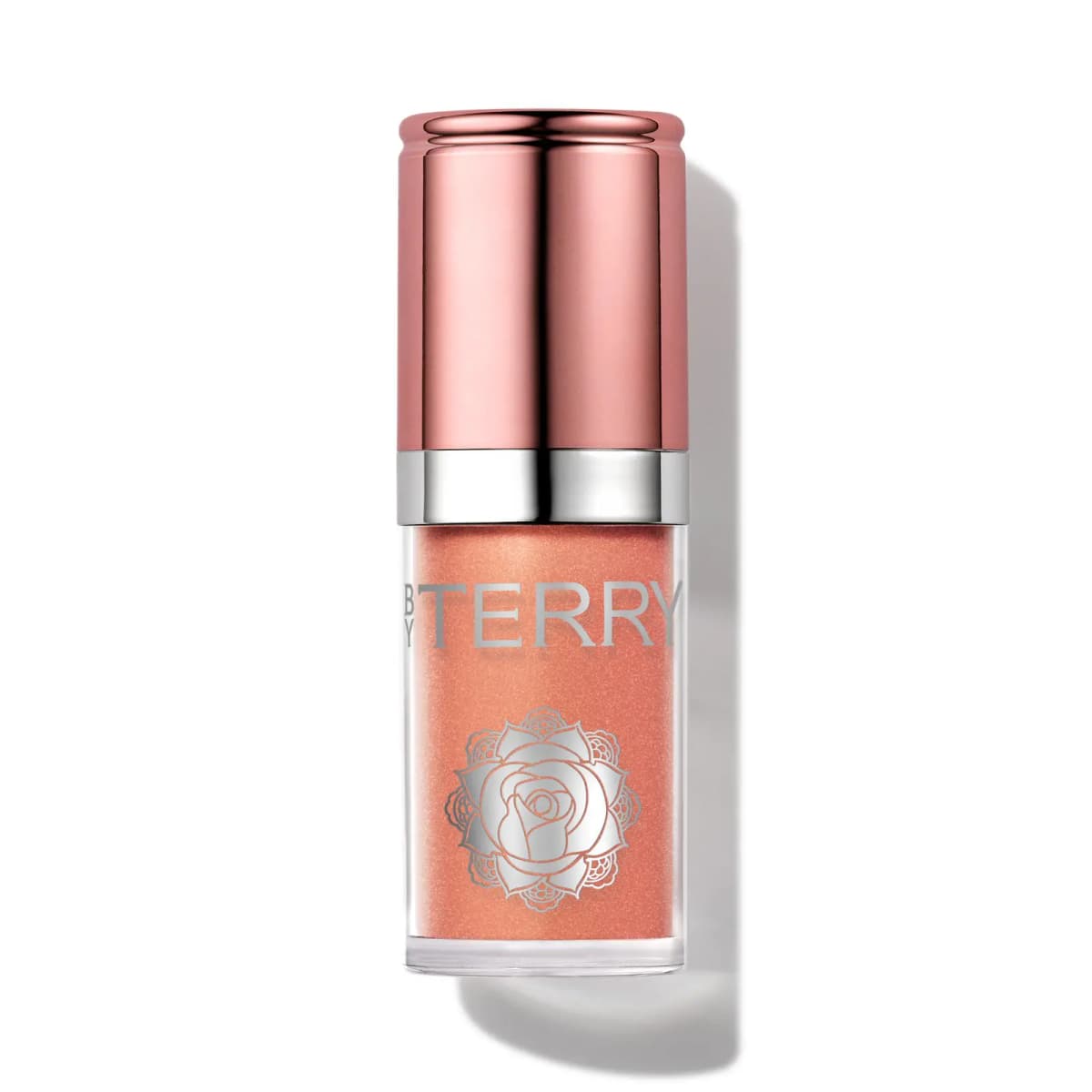 By Terry bottle in a shimmery peach shade with a large silver rose emblem and rose-gold cap, on white.