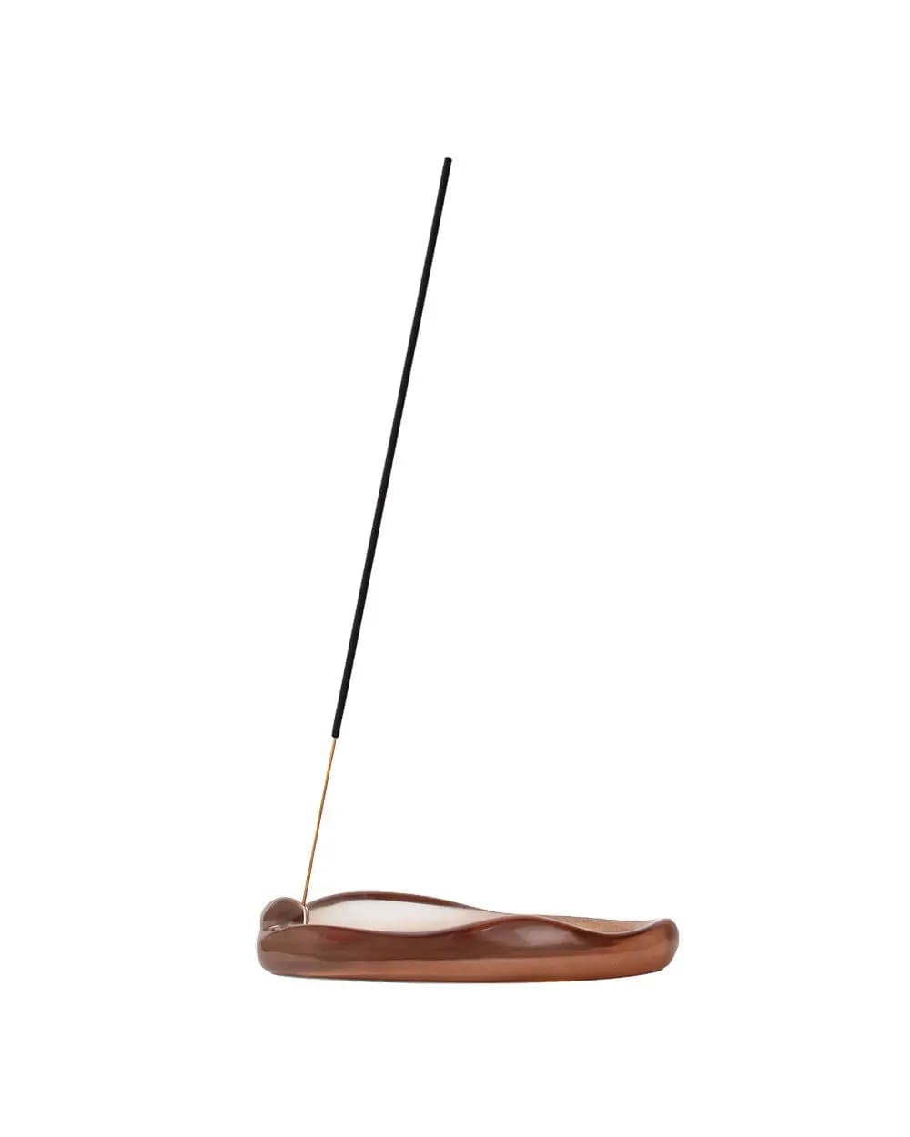 Black incense stick angled in a glossy brown wavy-edged ceramic holder