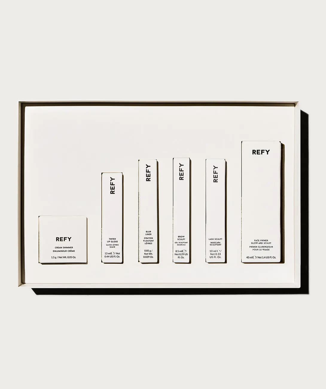 Open gift box insert with six boxed products: Cream Shimmer, Tinted Lip Gloss, Blur Liner, Brow Sculpt, Lash Sculpt