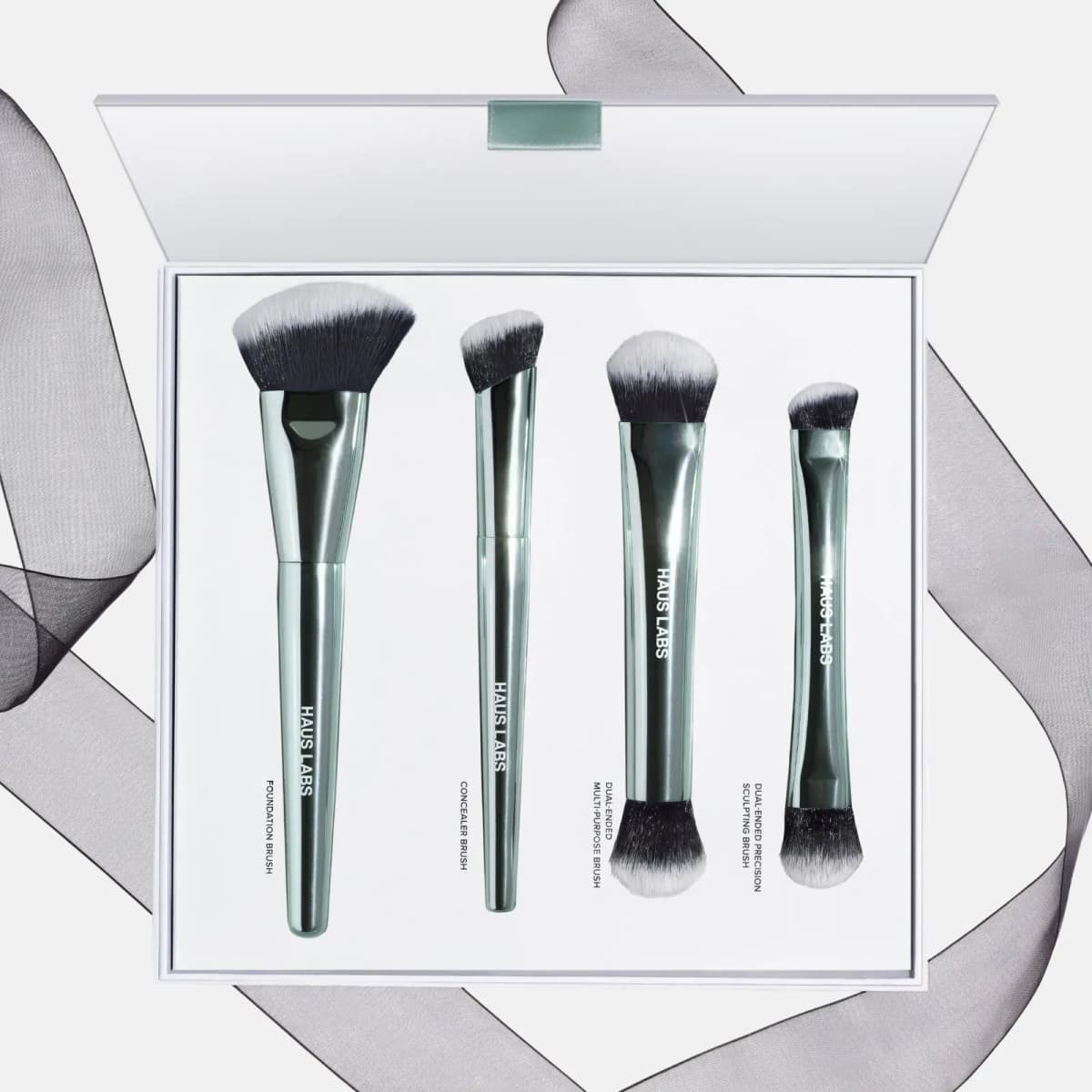 Open box holding foundation, concealer, dual-ended multi-purpose and dual-ended precision sculpting brushes