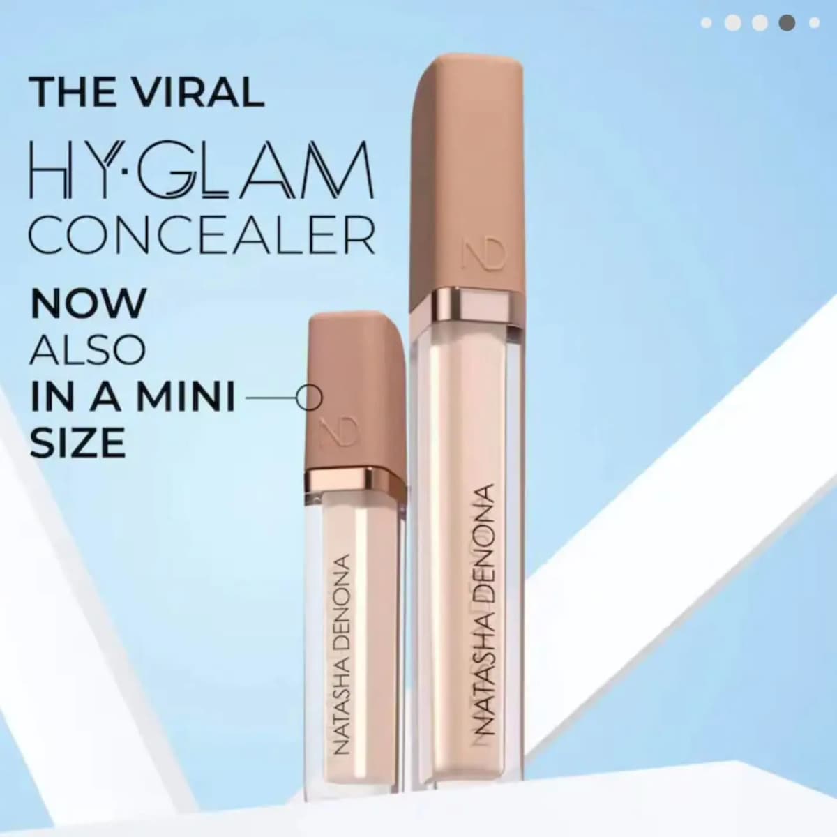 Natasha Denona Mini Hy-Glam Concealer beside the full size, both with tan caps and light shades, on a pale blue backdrop