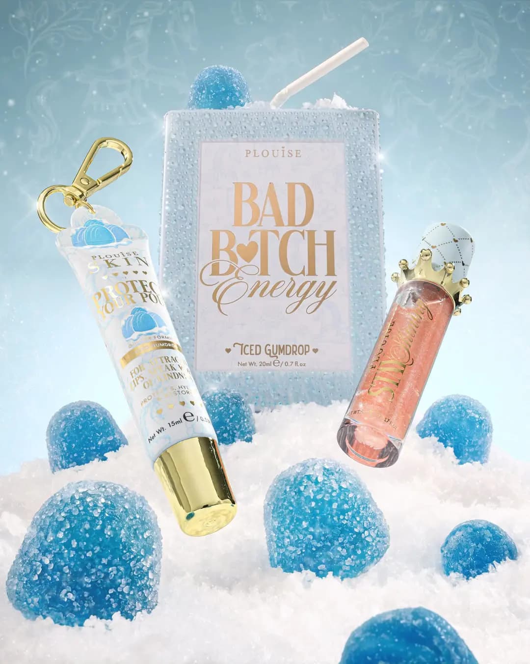 Iced Gumdrop Bad Bitch Energy crystal carton with a blue lip tube and coral gloss among sugared blue gumdrops