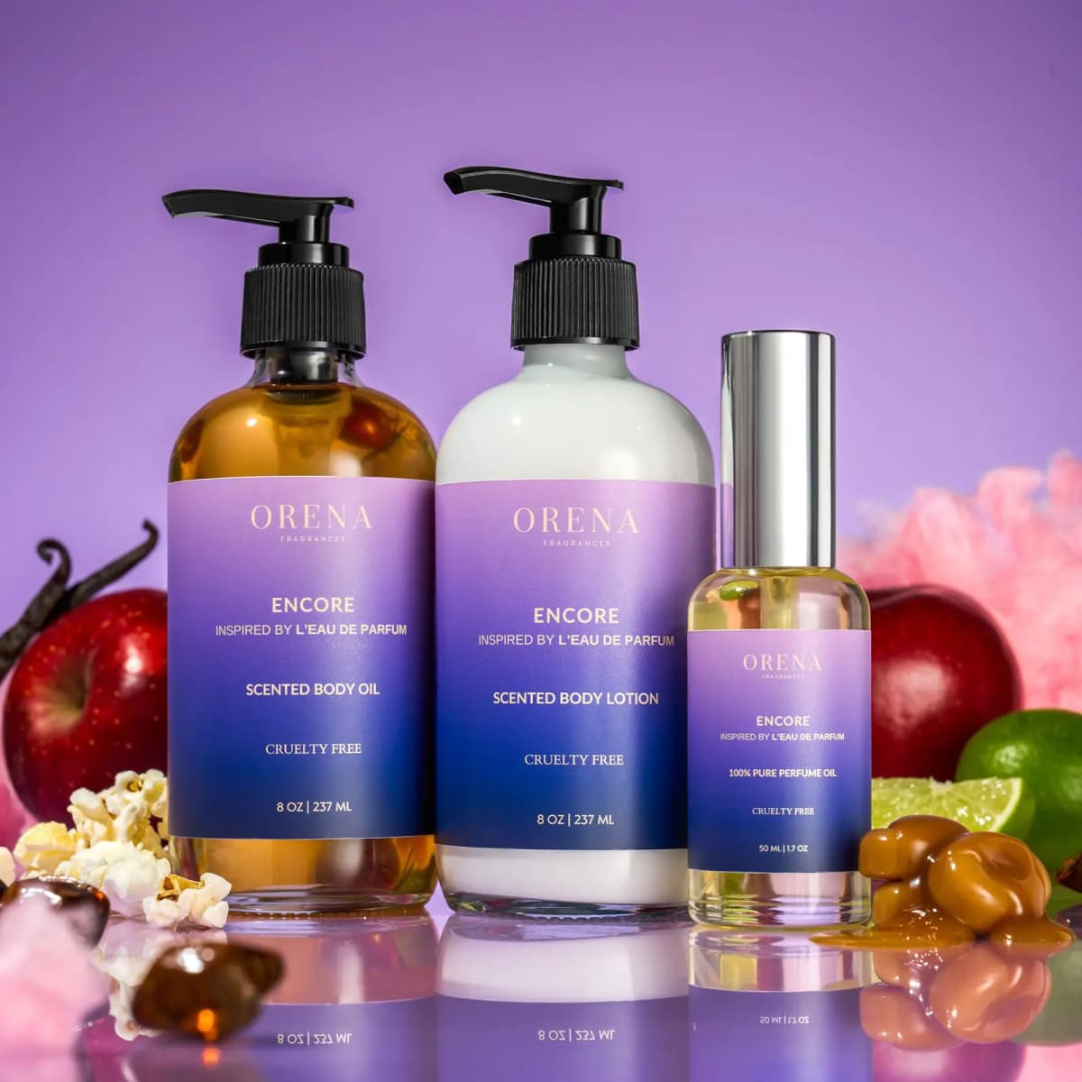 Encore trio with lilac-to-navy gradient labels beside apples, popcorn, caramel, lime and pink cotton candy on lavender