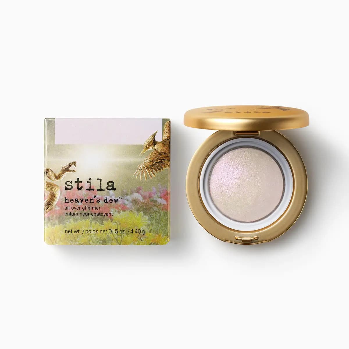 Heaven's dew all over glimmer, a pearly iridescent baked powder in an open gold compact beside its floral box