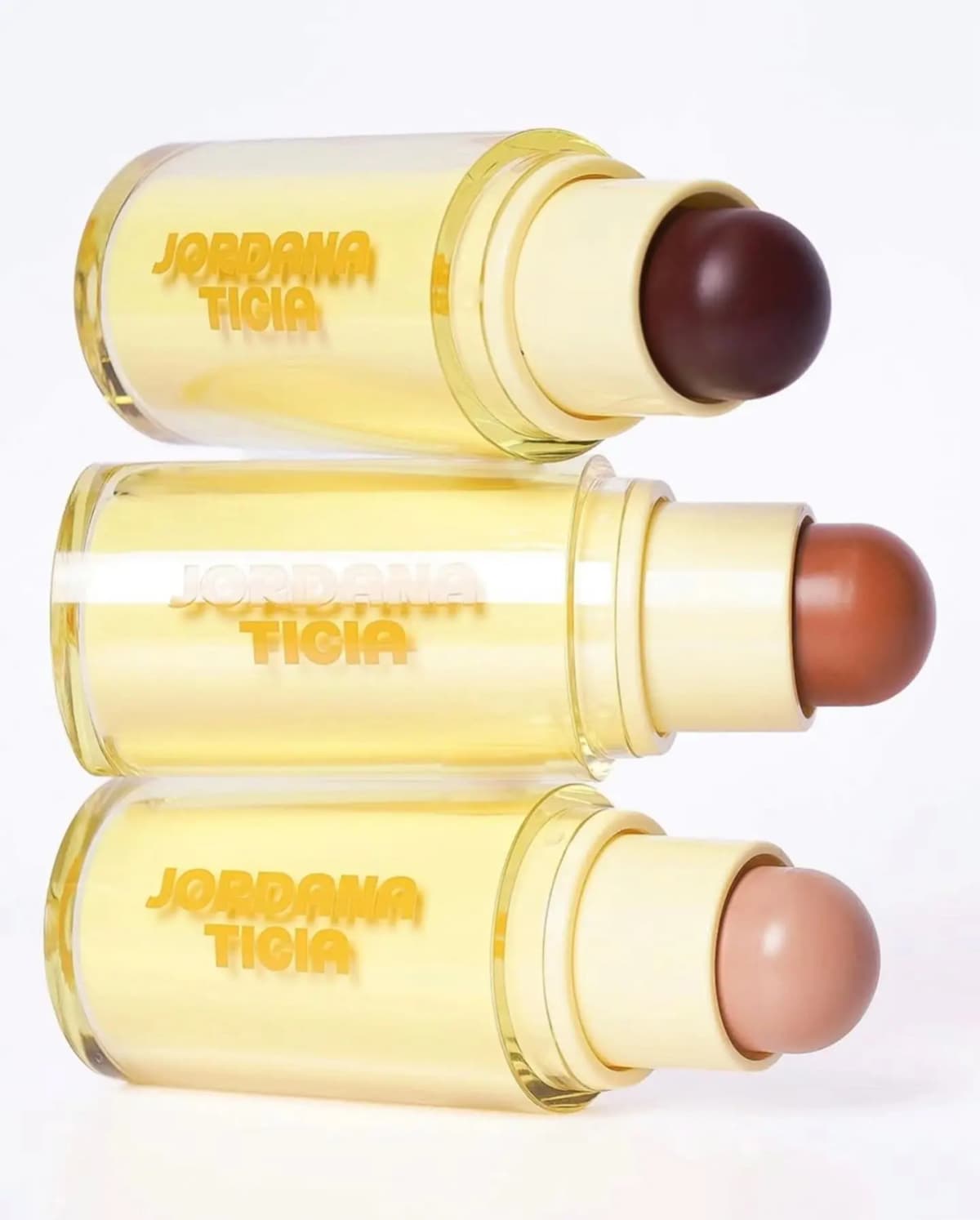 Three horizontal Jordana Ticia sticks stacked, bullets in deep brown, warm terracotta and light beige