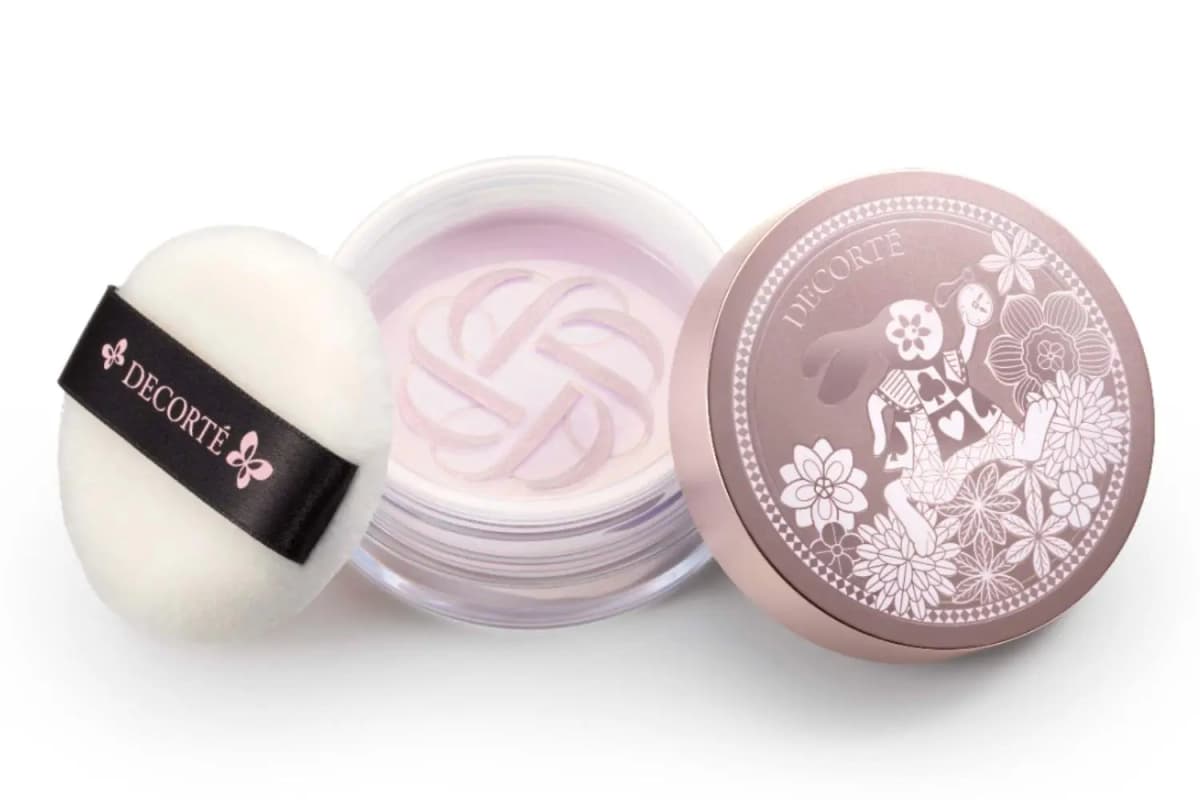 Open DECORTÉ loose powder in pale lavender with black-ribbon puff and White Rabbit pocket-watch lid