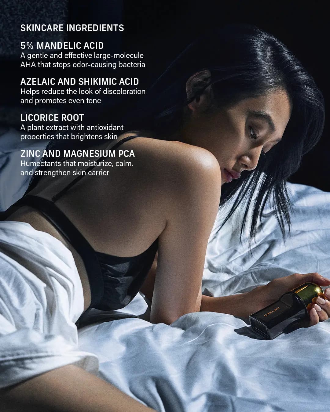 Woman in a black bra lying on white sheets holding the deodorant, beside a list of skincare ingredients