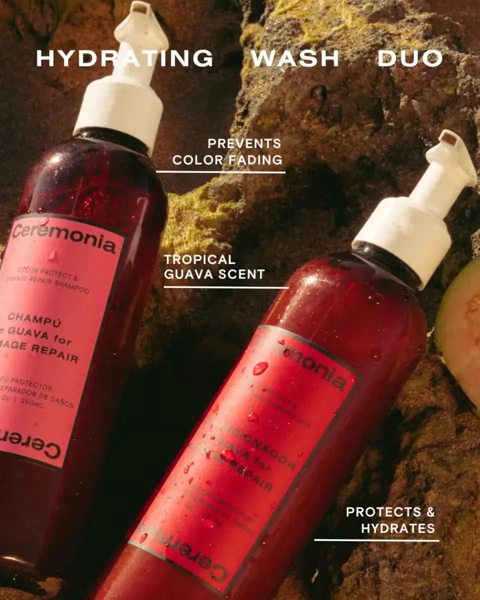 Wet Guava shampoo and conditioner bottles lying on mossy rocks under 'Hydrating Wash Duo' text with a sliced guava