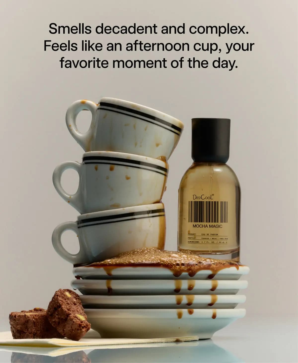 Stacked espresso-stained cups beside DedCool Mocha Magic bottle with text about a decadent afternoon cup