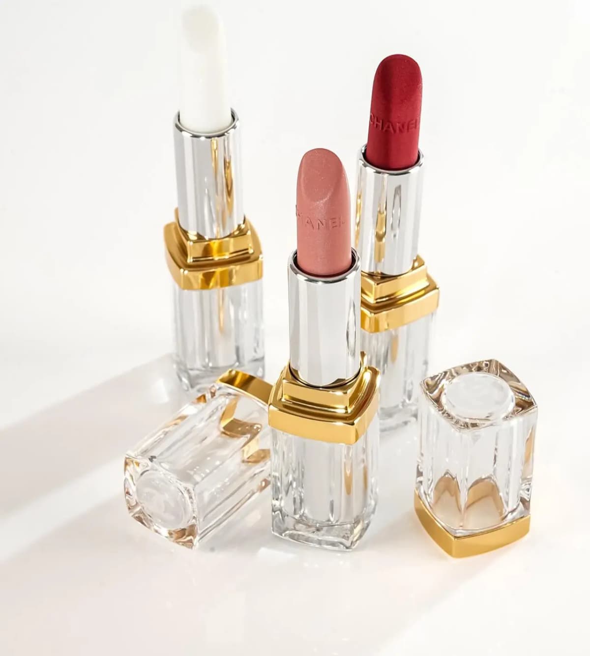 Chanel Holiday 2026 lipsticks in white, pink and red with gold-trimmed clear cases