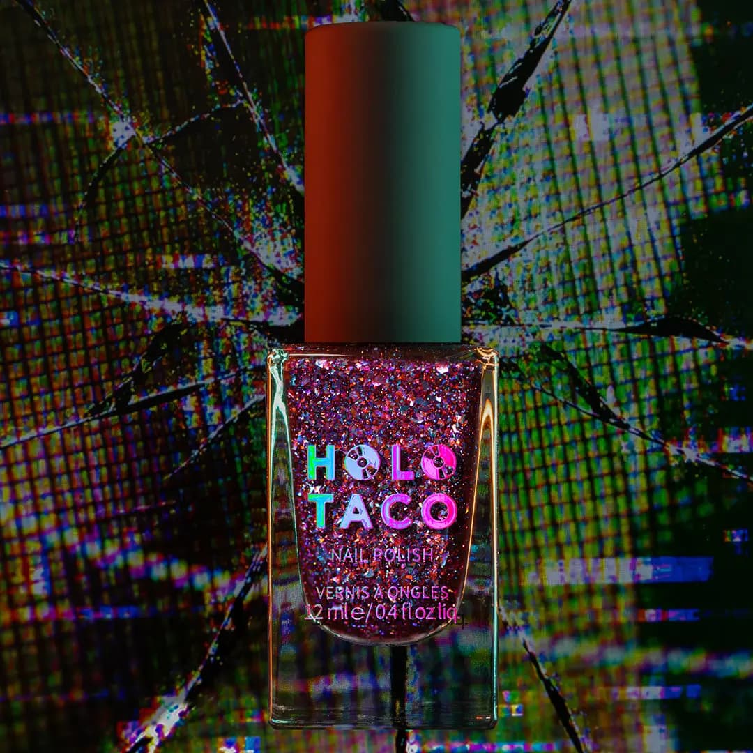 Bottle of berry red jelly polish packed with pink and blue iridescent flakes on a glitch background