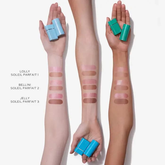 Three arms of varying skin tones showing bronzer and blush swatches with colored product cases in hand