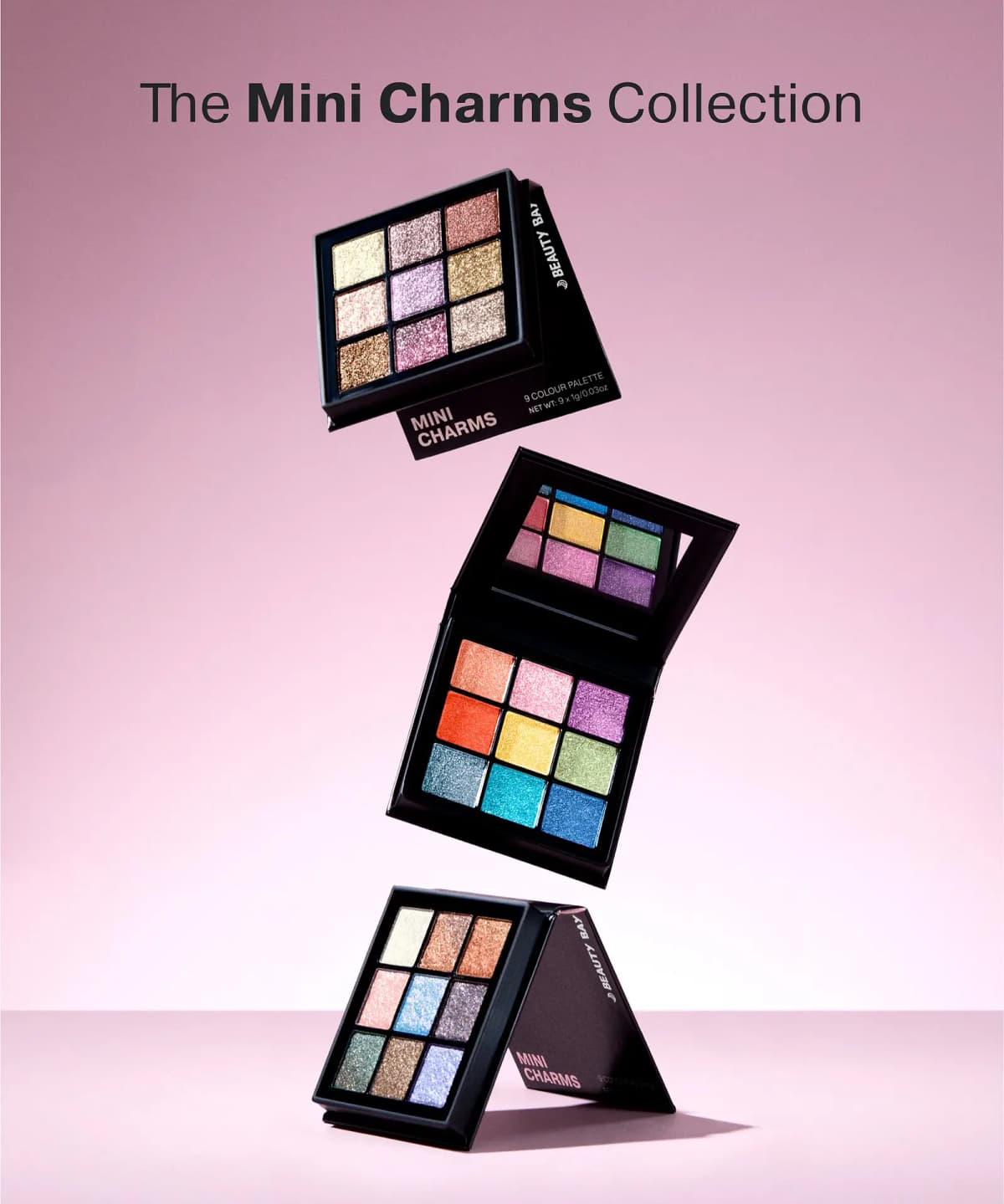 The Mini Charms Collection: three By BEAUTY BAY nine-pan shimmer palettes floating against a pink backdrop
