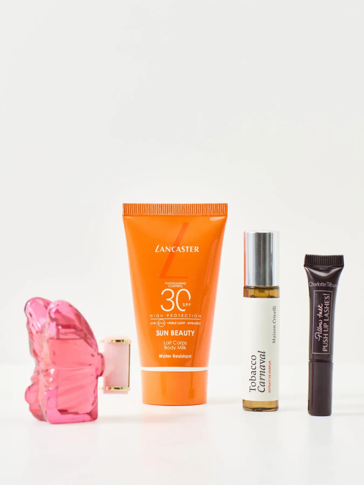 Carolina Herrera La Bomba pink flower bottle, Lancaster SPF30 Sun Beauty body milk, Maison Crivelli Tobacco Carnaval, Charlotte Tilbury Pillow Talk mascara