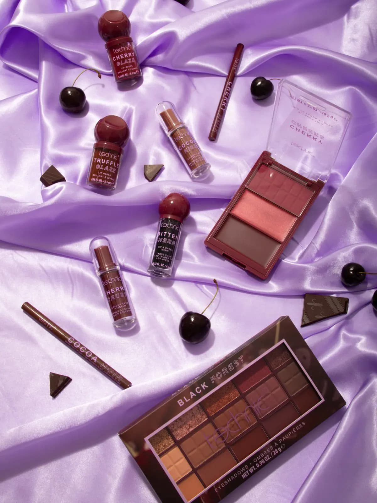 Technic Cherry Chocolate Collection laid out on lilac satin with cherries, chocolate pieces and the Black Forest palette