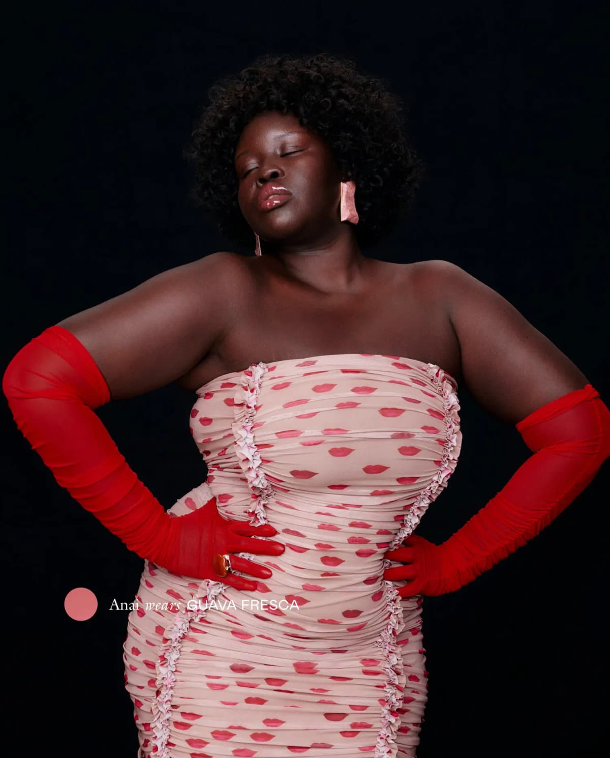 Anai in a lip-print strapless dress and red opera gloves wears glossy Guava Fresca