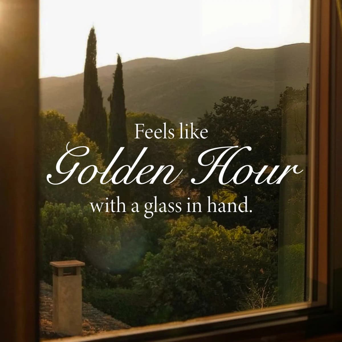 View through a window of cypress trees and hills at dusk, with Feels like Golden Hour text overlay