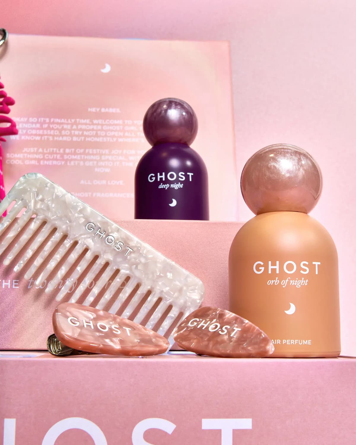 Ghost Deep Night and Orb of Night hair perfumes with a pearly white comb and two pink marbled hair clips