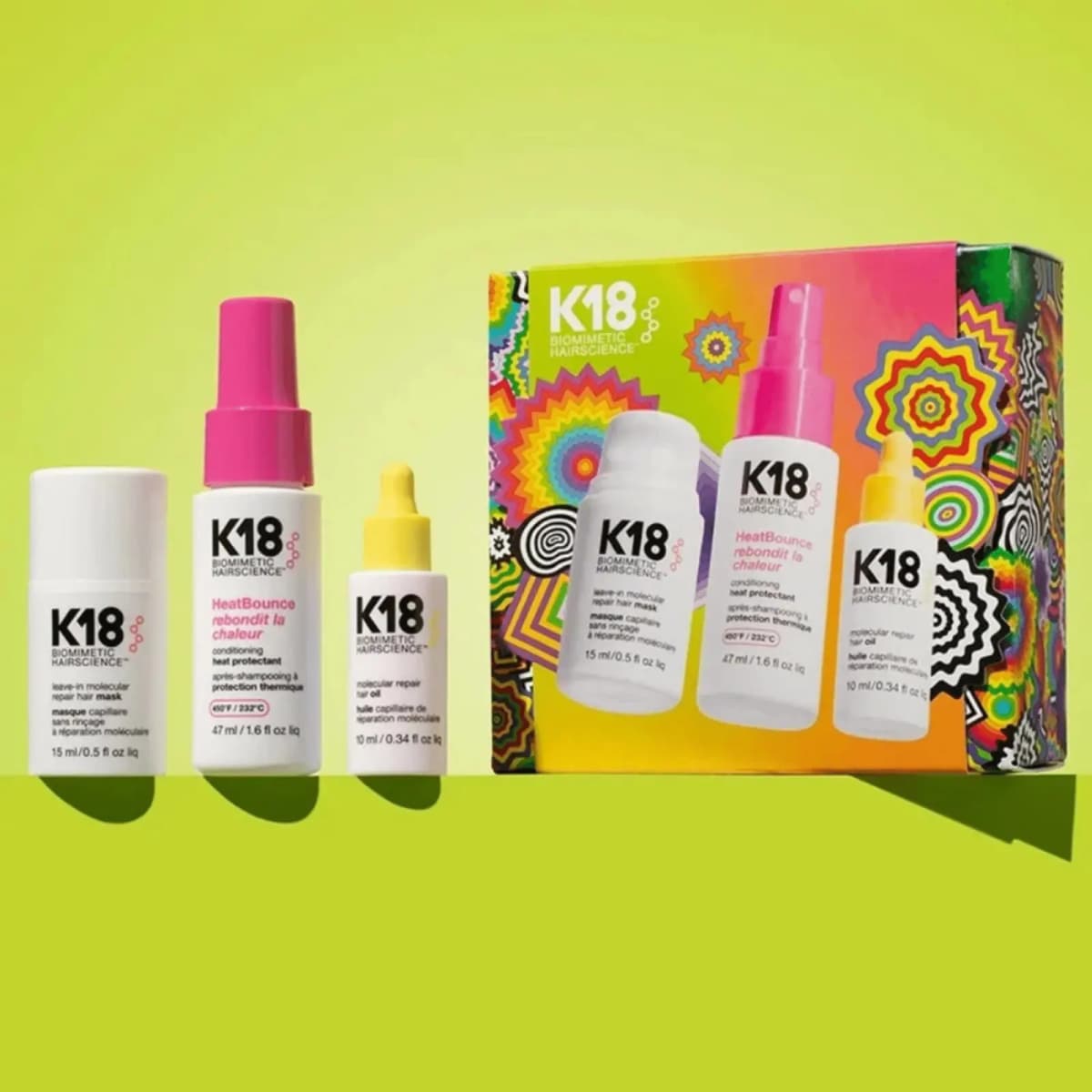 K18 mask, HeatBounce and oil minis in a row on a lime green ledge next to the Jen Stark designed gift box