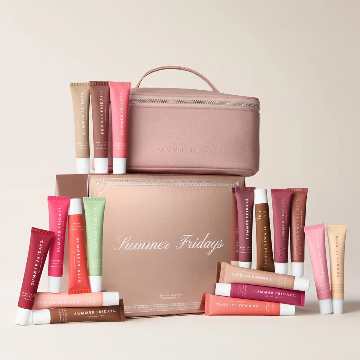 Blush vegan leather vanity case atop a rose-gold Summer Fridays box, surrounded by 18 Lip Butter Balm tubes on cream