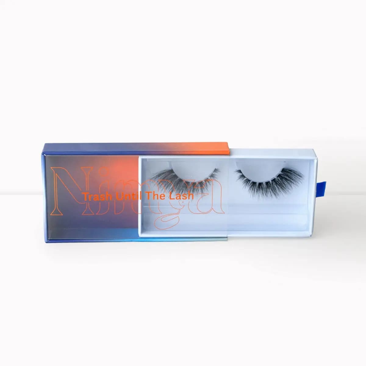 Open Nimya lash case revealing a fluffy cat-eye style strip lash with longer outer corners.