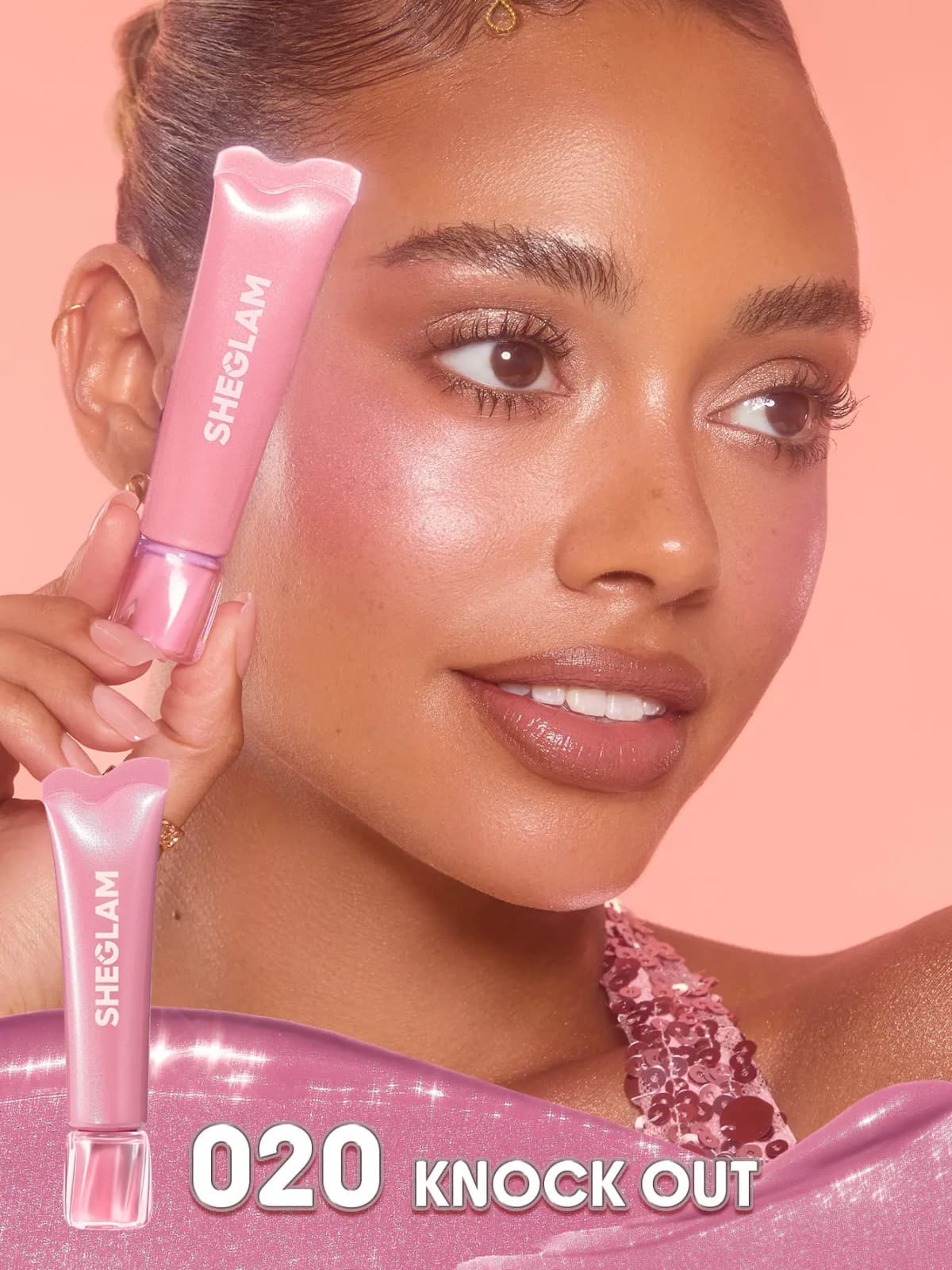Model with glowing pink cheeks holds a pink tube by the face, labelled 020 Knock Out