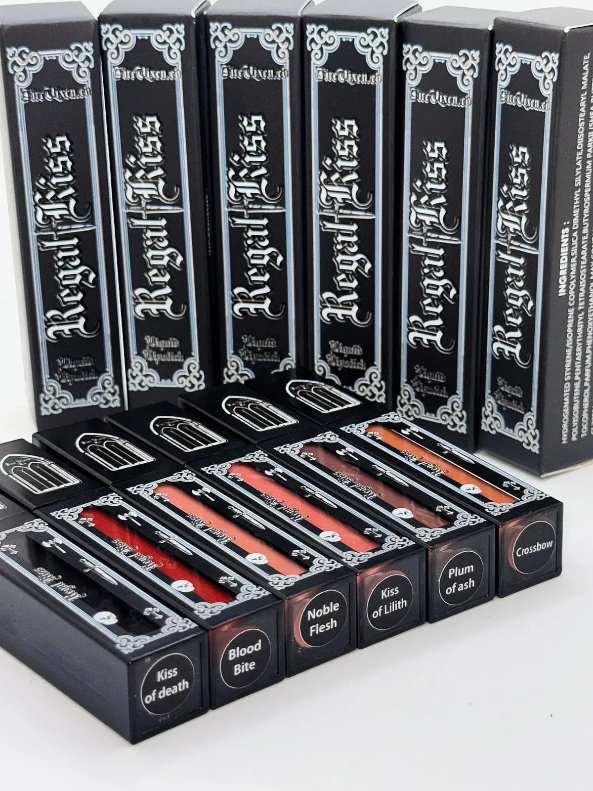 Regal Kiss boxes stand behind six tubes labelled Kiss of death, Blood Bite, Noble Flesh, Kiss of Lilith, Plum of ash