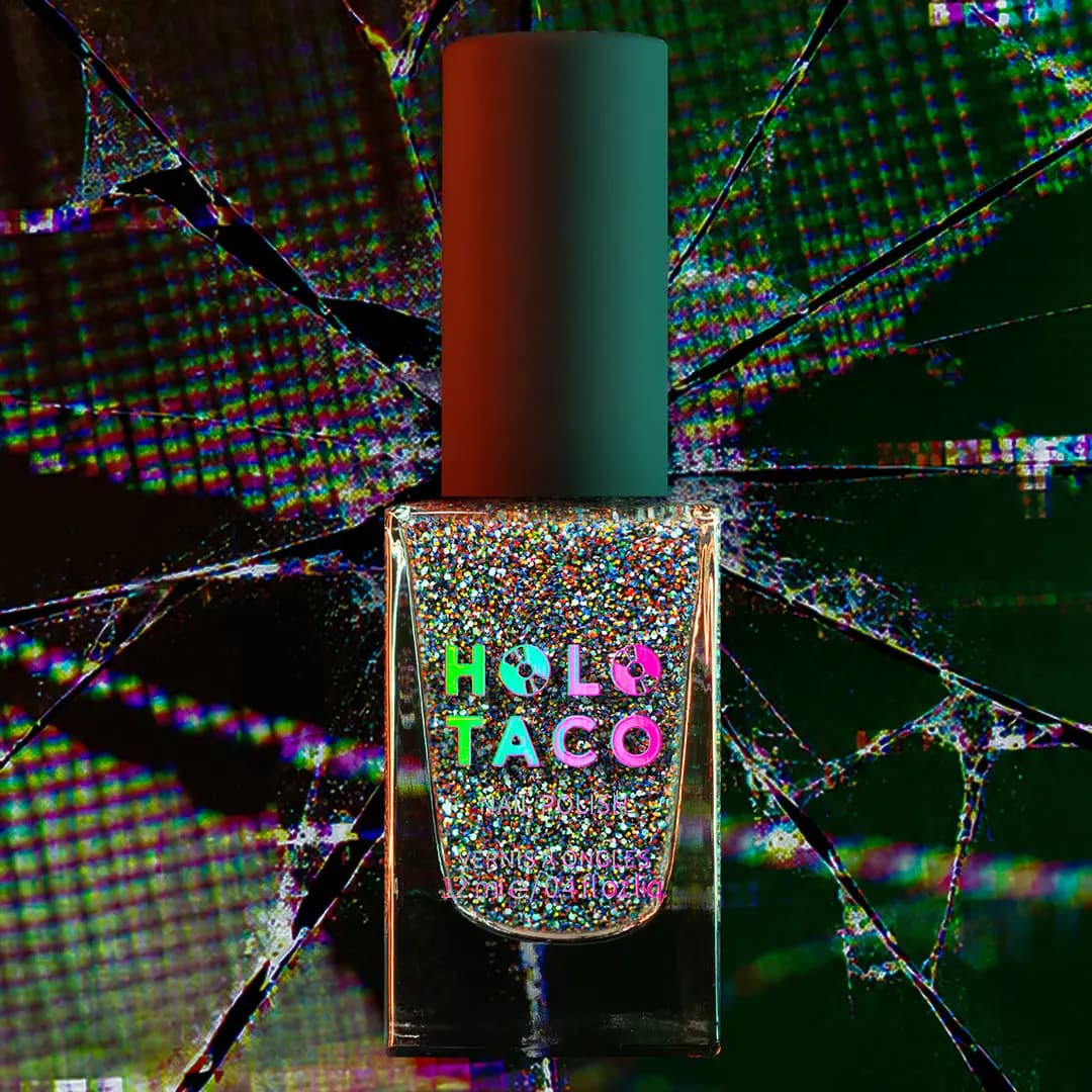 Bottle of dense multicolour rainbow micro-glitter polish against a cracked digital screen backdrop