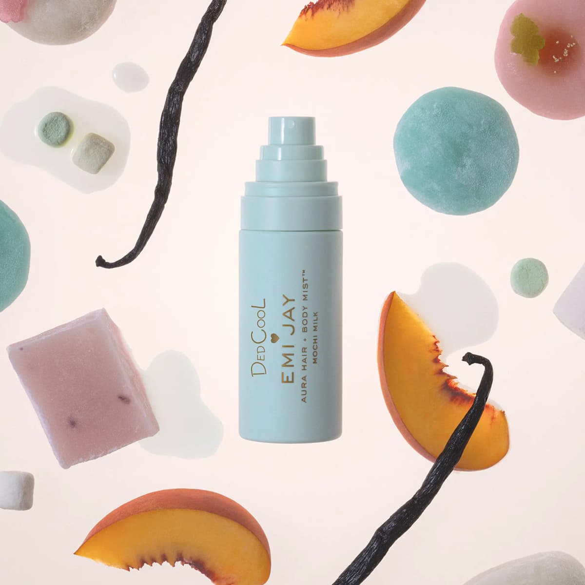 Mint Aura Hair + Body Mist bottle surrounded by floating peach slices, vanilla beans, mochi and milky drops