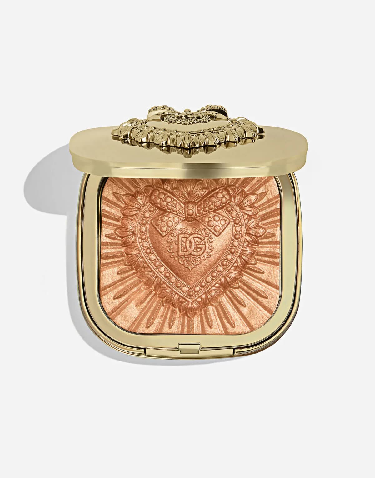 Open gold compact with a warm bronze-copper highlighter pan embossed with a radiating DG heart