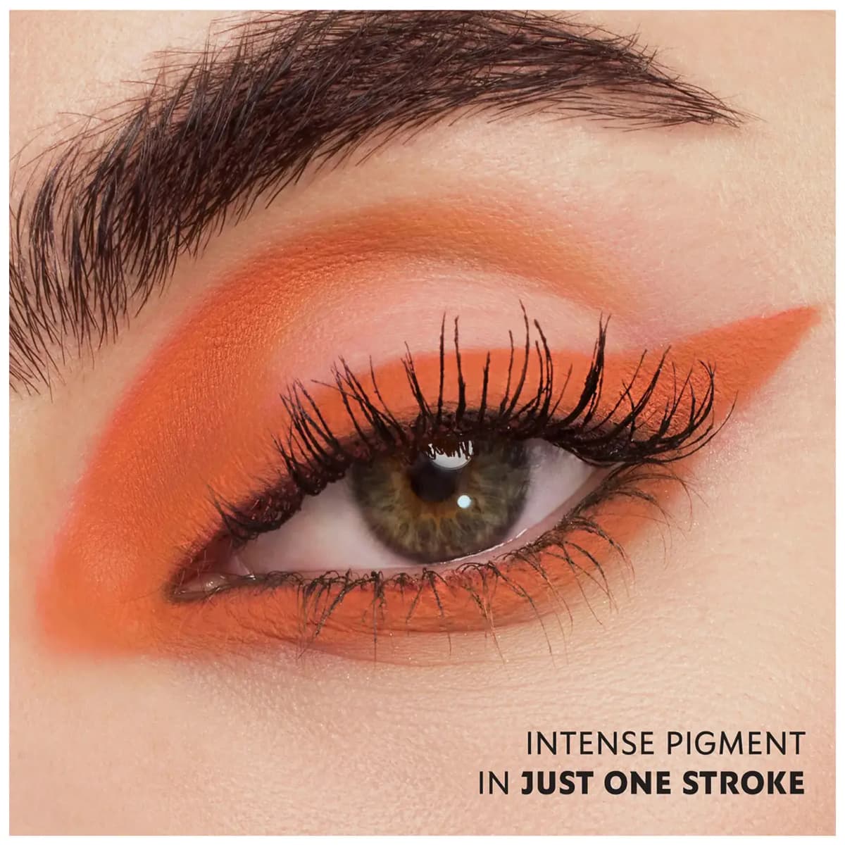 Hazel-green eye with bold matte orange graphic liner sweeping into the crease and along the lower lash line.