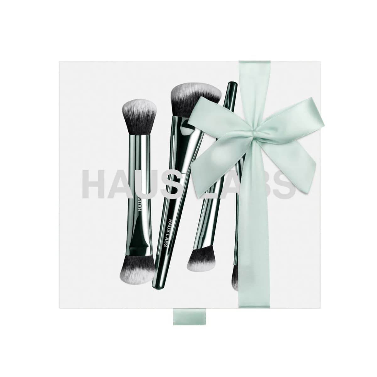 White Complexion Brush Set box showing four green-chrome brushes and HAUS LABS text, with a mint satin bow
