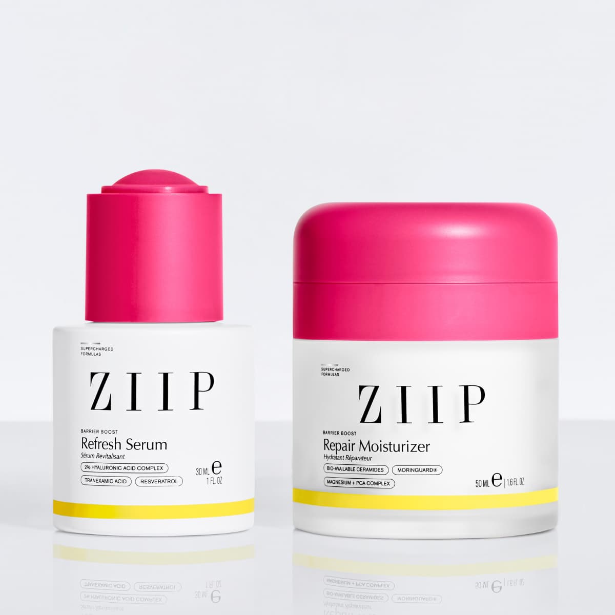 Refresh Serum and Repair Moisturizer pair with pink caps reflected on a white surface