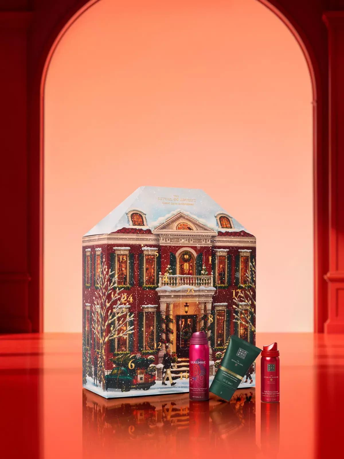Townhouse calendar with three travel minis on a glossy red surface before a glowing peach archway