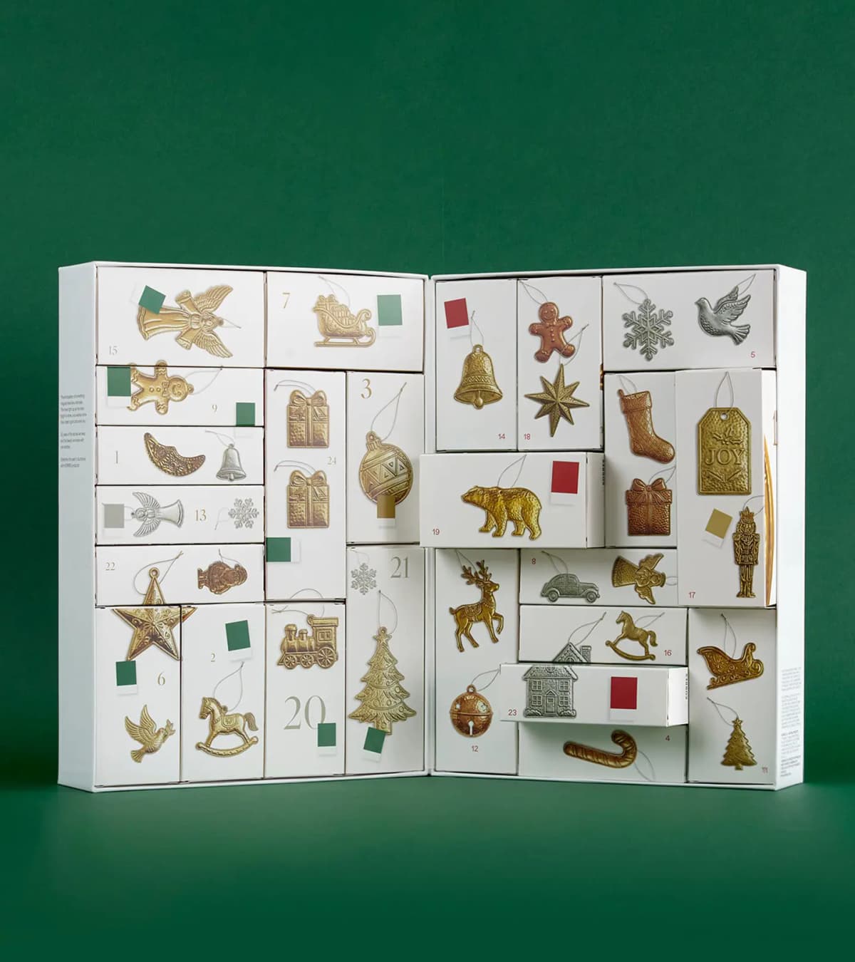 Open calendar on green backdrop, numbered boxes showing gold and silver ornament illustrations with colour swatches