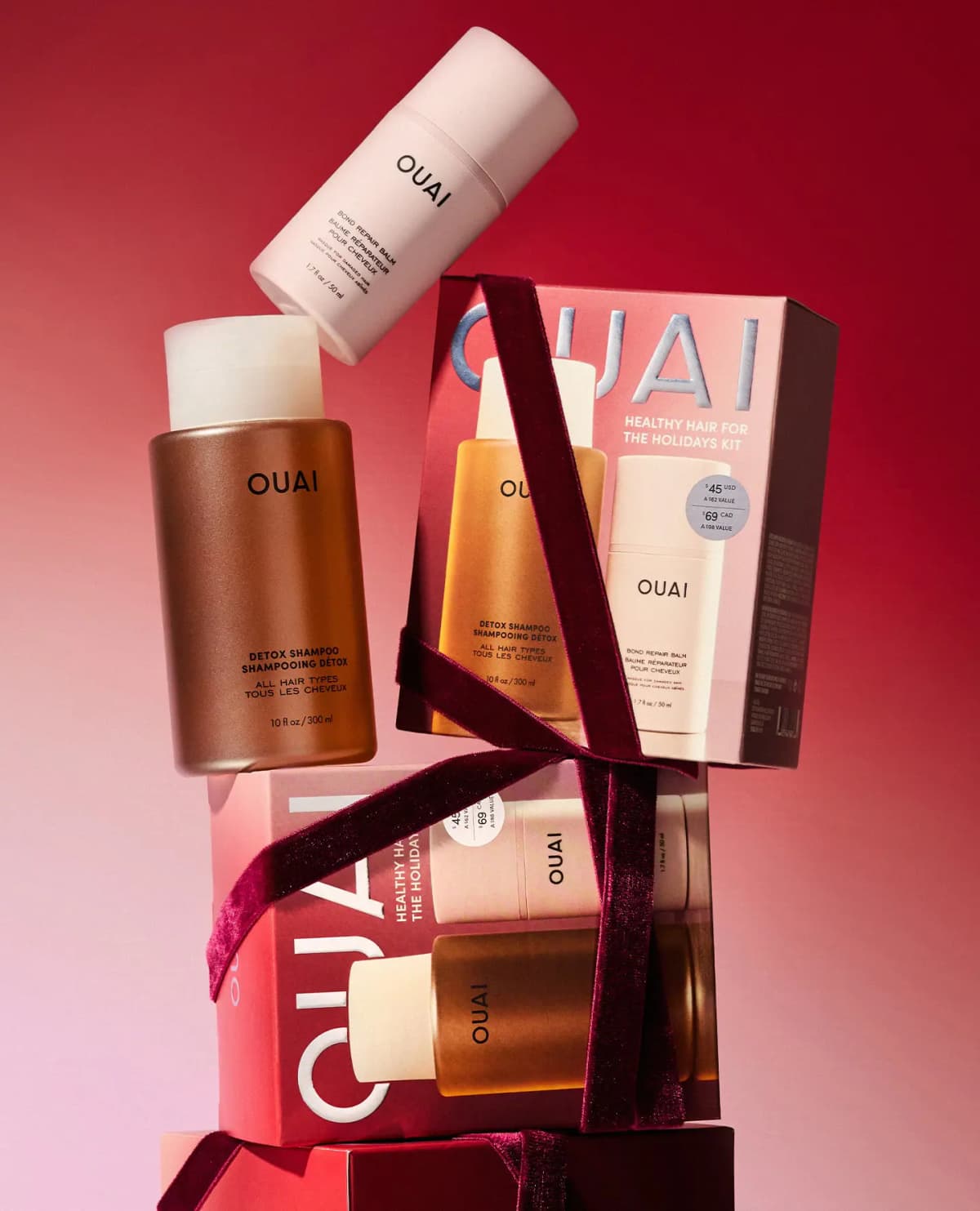 Shampoo bottle and balm tube stacked atop two ribbon-tied kit boxes showing $45 USD and $69 CAD price sticker