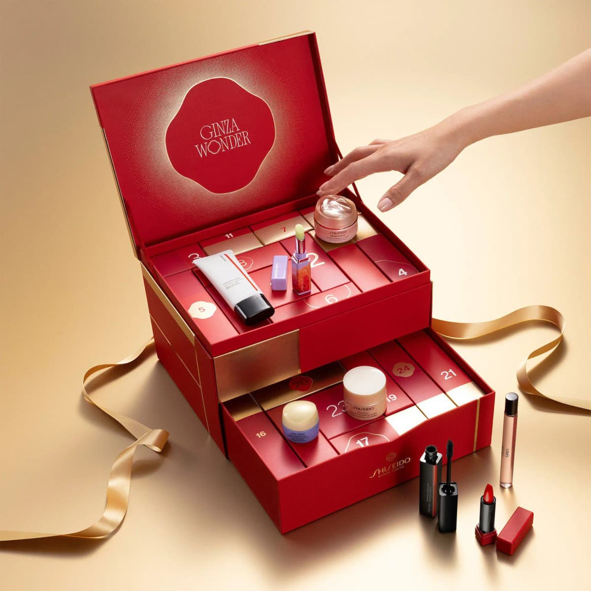 Open red and gold Ginza Wonder Shiseido advent calendar with two tiers of numbered drawers, skincare jars, lipstick and