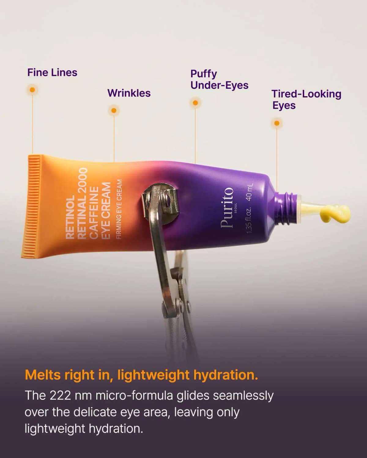 Purito eye cream tube held by an eyelash curler with labels pointing to fine lines, wrinkles, puffy and tired eyes.