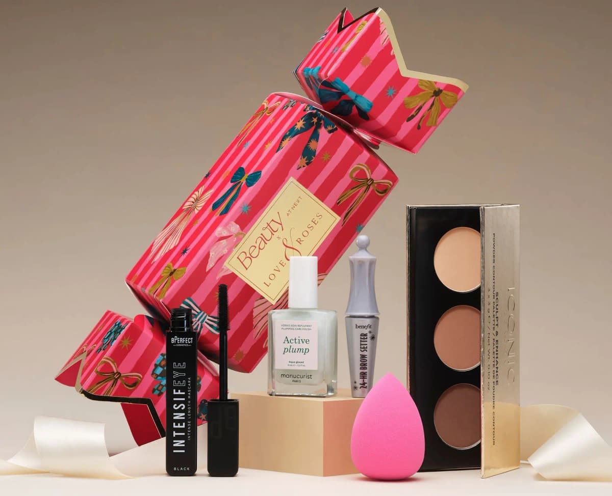 Pink bow-print makeup cracker with BPerfect mascara, Manucurist polish, Benefit brow setter, sponge and Iconic palette