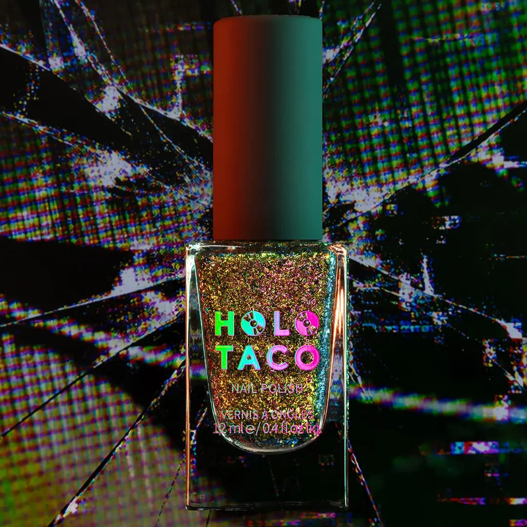 Bottle of gold and pink multichrome flake polish against a shattered glitch-effect background