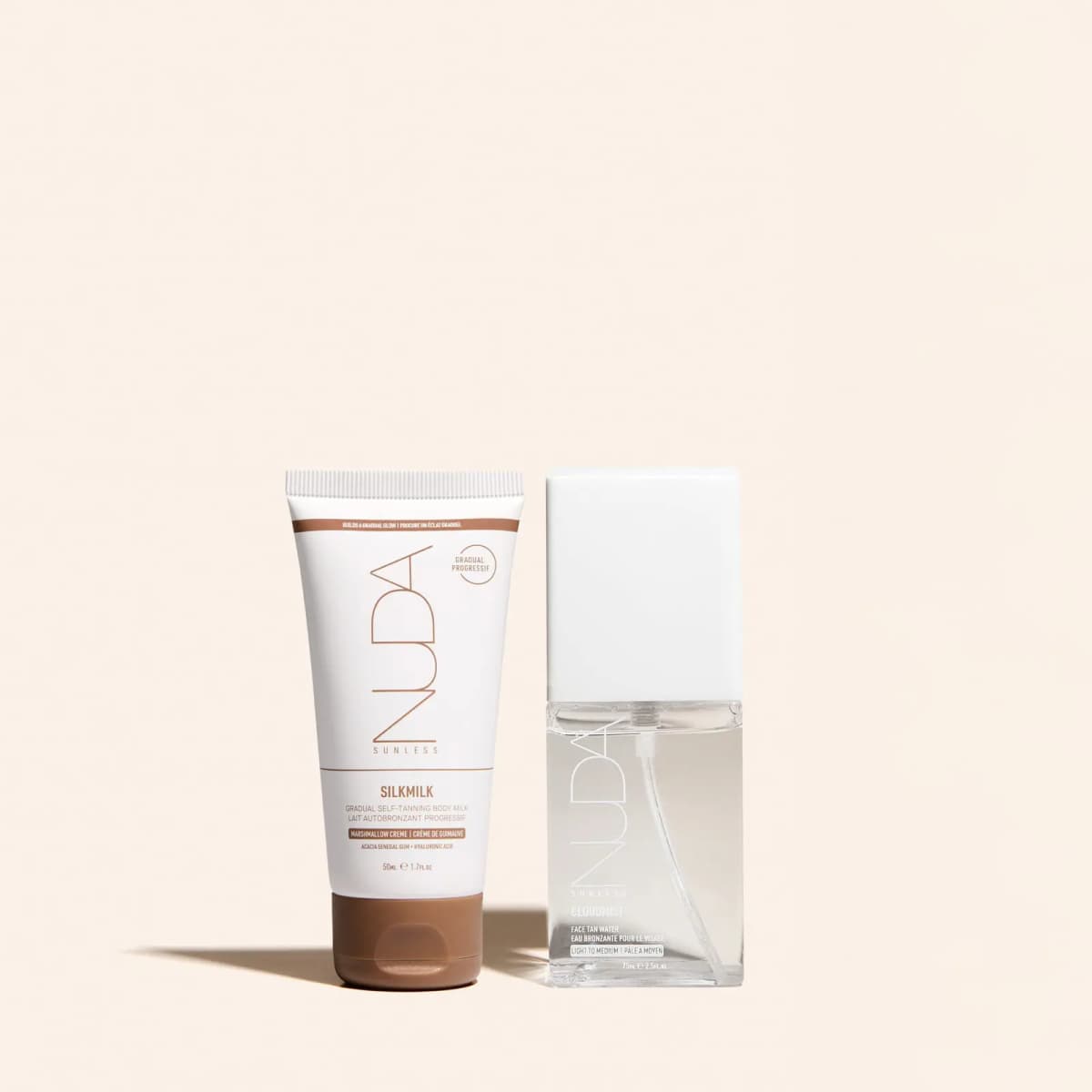 White SilkMilk gradual self-tanning body milk tube beside a clear CloudMist Face Tan Water bottle on cream.