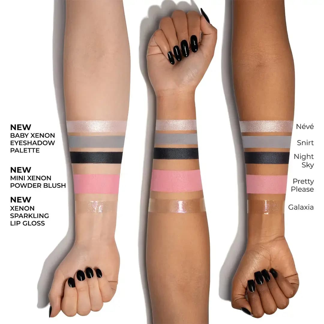 Three arms with black nails showing Baby Xenon shadow, Pretty Please blush and Galaxia sparkling gloss swatches.