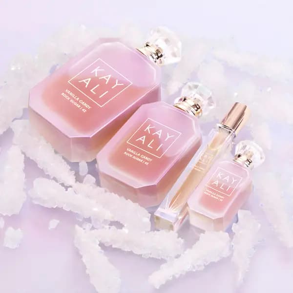 Kayali Vanilla Candy Rock Sugar 42 in 100 ml, 50 ml and 10 ml bottles plus a travel spray, surrounded by rock sugar crystals